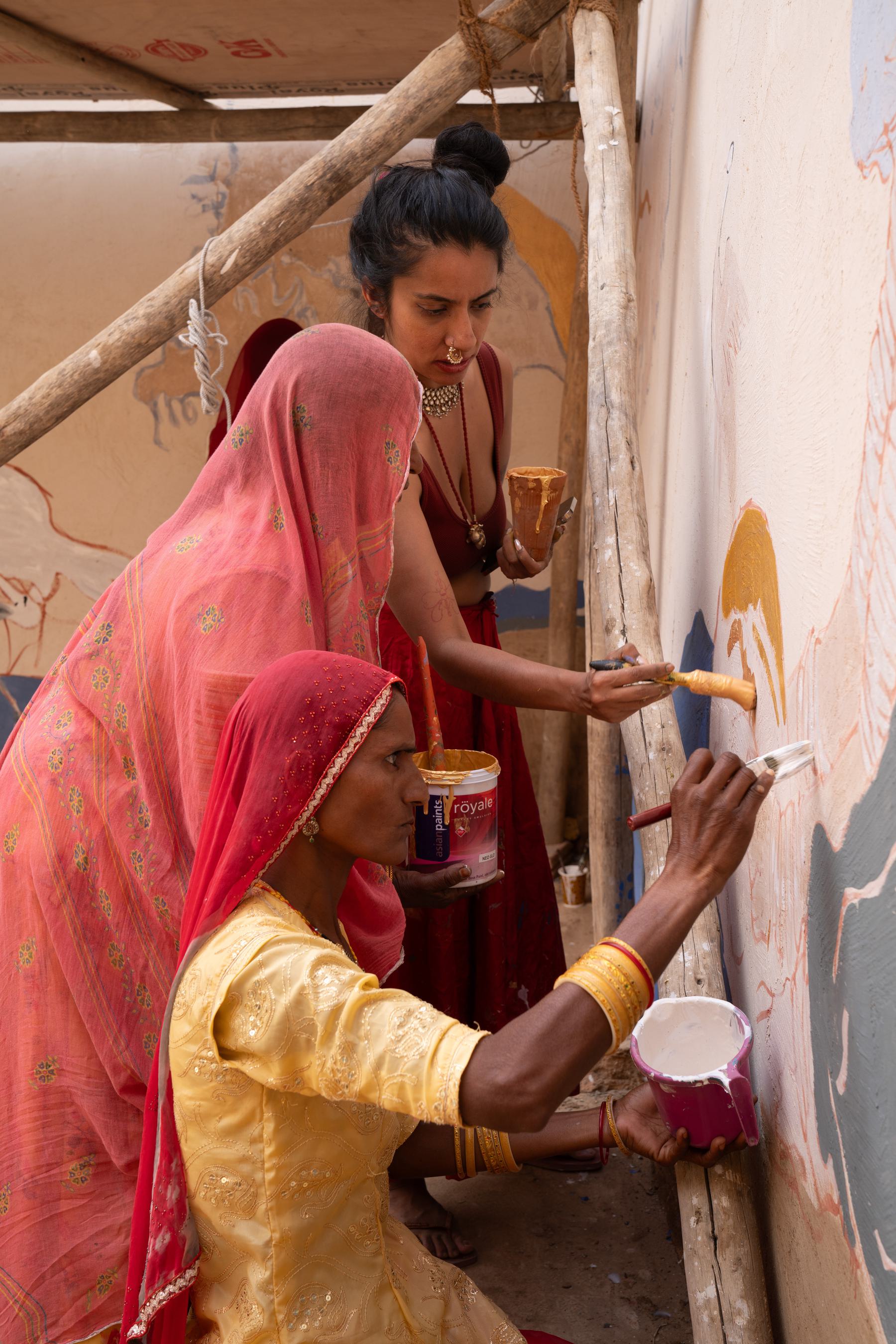 3 women paint a mural together