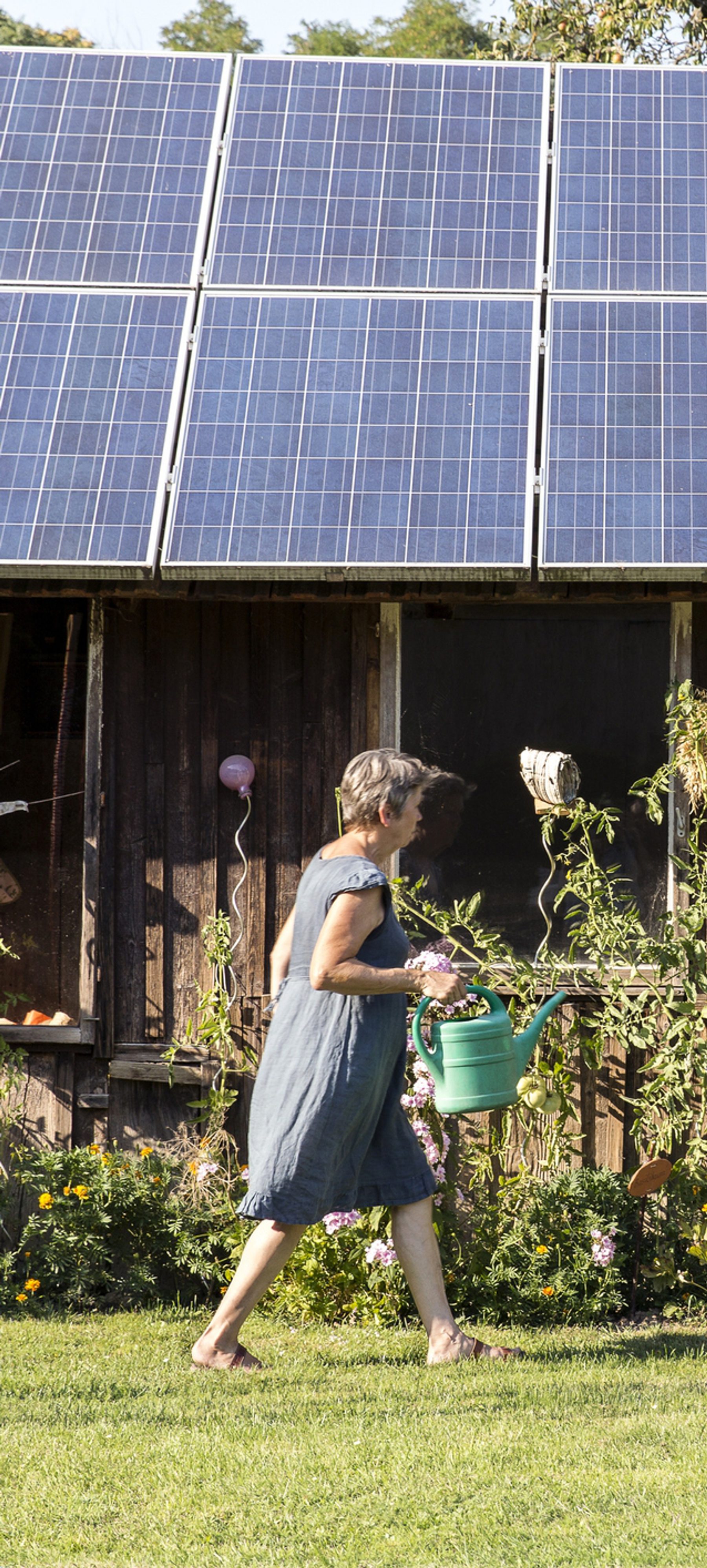 woman walking in front of a solar powered home