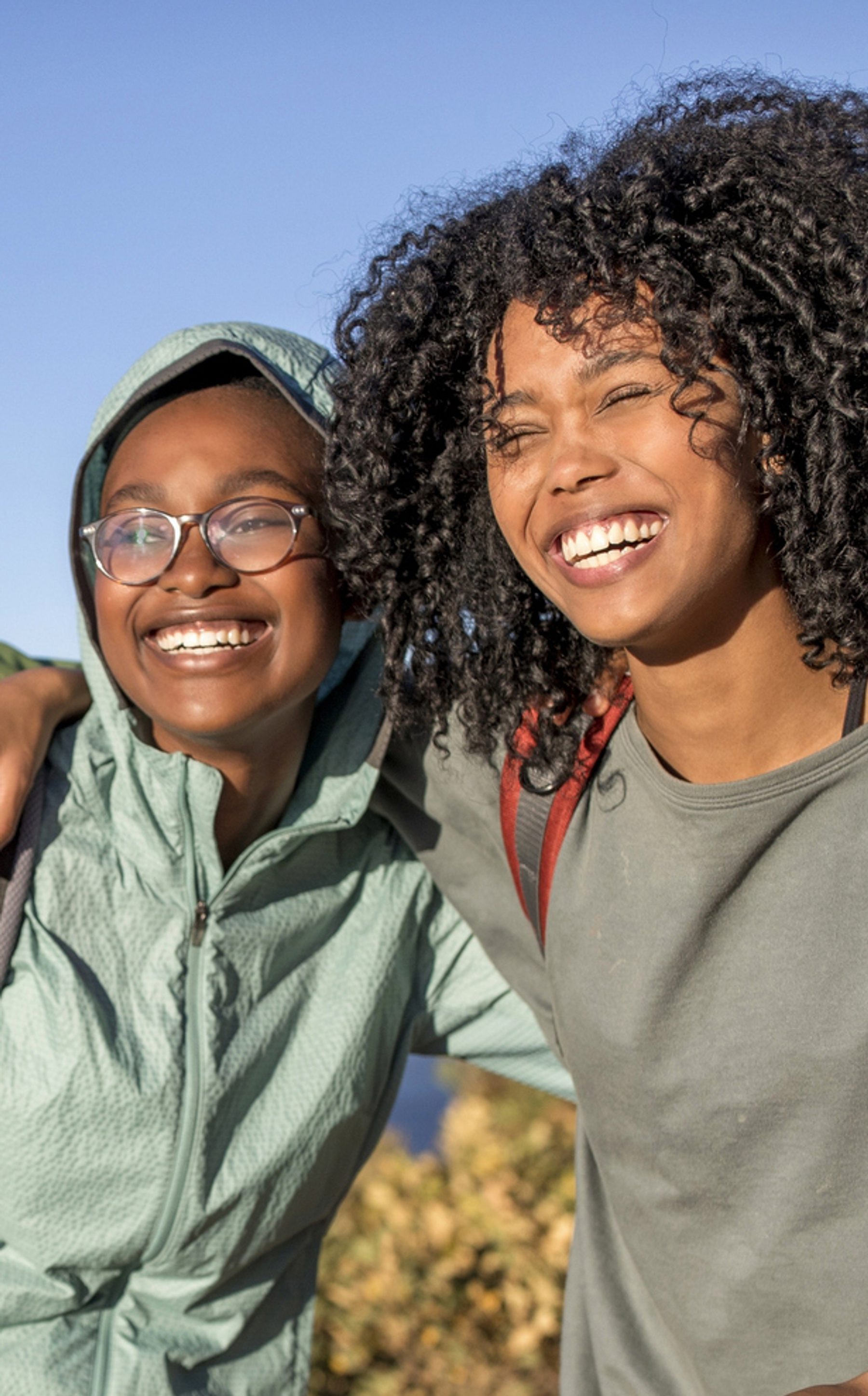 two beautiful black women holding onto each other and smiling