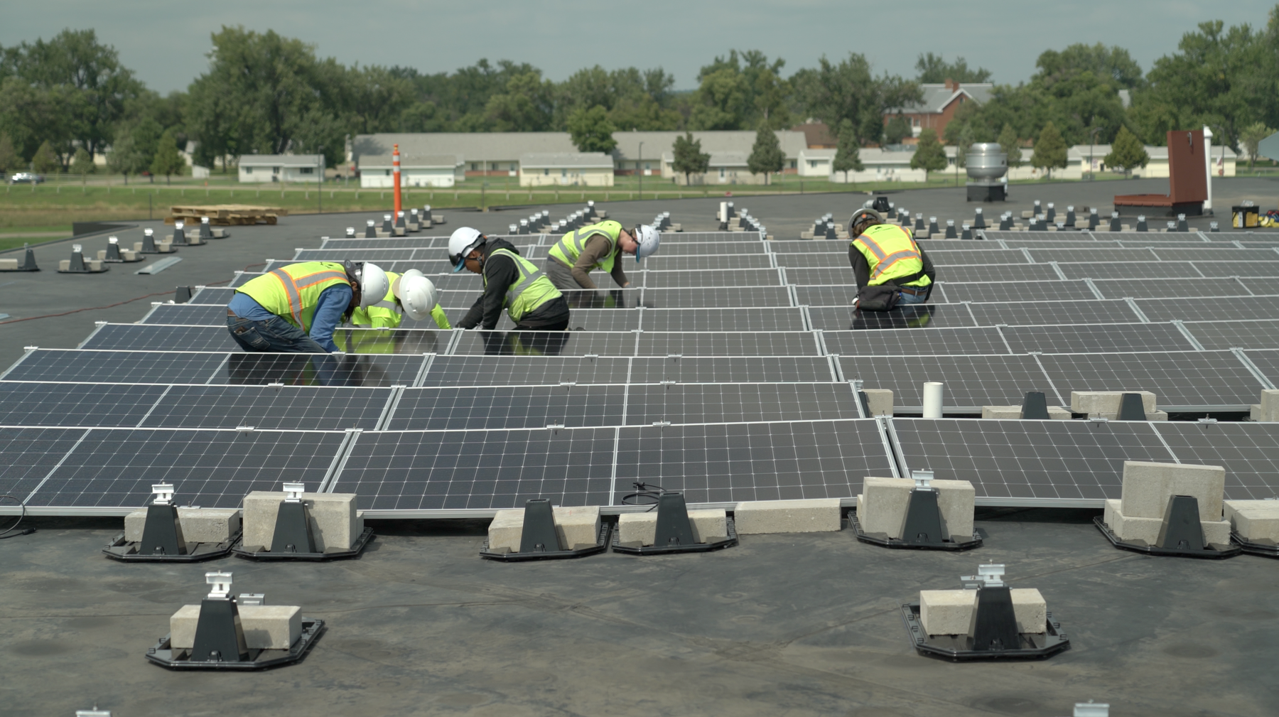 workers installing solar panel rooftops