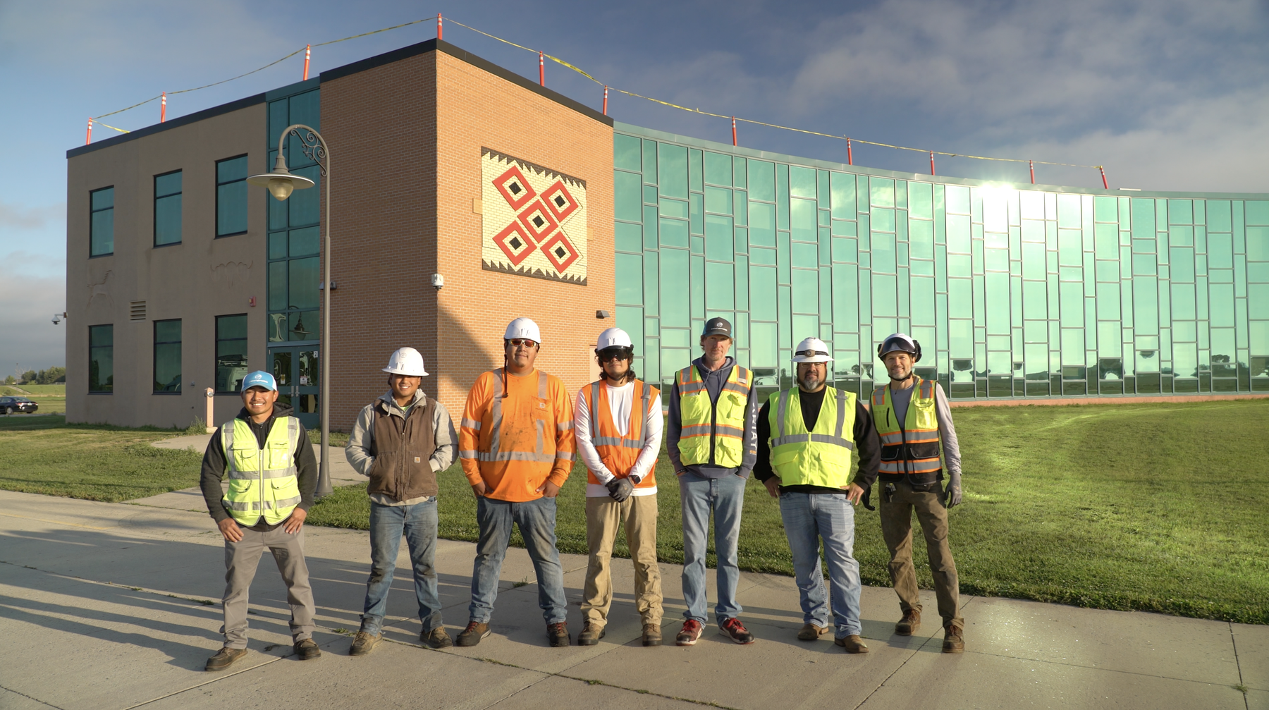 A group or workers are standing in front of a building